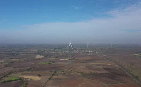 Close Aerial Perspective of Spinning Wind Turbine Blade Over Wide Agricultural Vídeo Stock 342489220