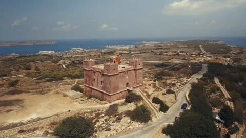 Close Aerial shot rotating around St Agatha's Red Tower in Mellieha Malta Stock Footage 90632328