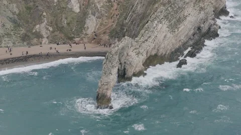 Close Aerial Side View of Durdle Door Sea Arch and Breaking Waves Stock Footage 346737917