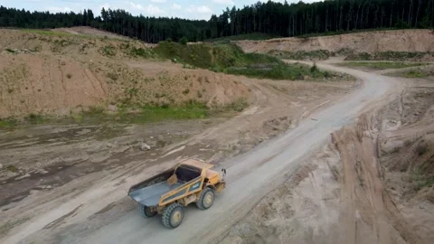 Close up aerial side view of yellow quarry dump earthmoving truck riding Stock Footage 170387802