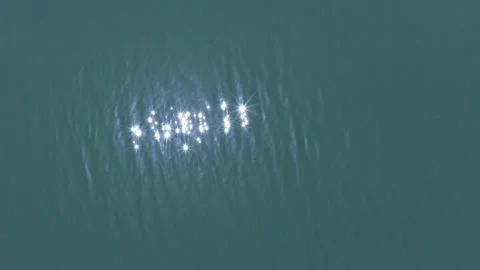 Close aerial view of bright sunlight sparkling and reflecting on the surface of Stock Footage 337991214