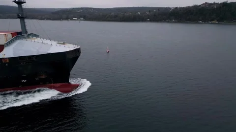 Close aerial view of container ship bow moving through calm water, creating whit Видео 325741258