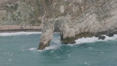 Close Aerial View of Durdle Door Limestone Sea Arch and Breaking Waves Stock Footage 346737724