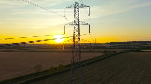 Close aerial view of high voltage electricity pylon beside farmland during Vídeo Stock 345126448