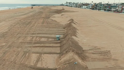 Close aerial view of large sand mounds and protective beach barriers Видео 347566905