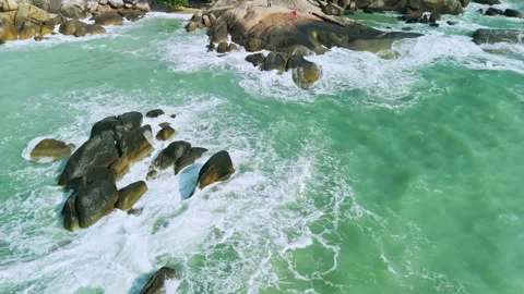 Close aerial view of ocean waves hitting giant stones Stock Footage 331282270