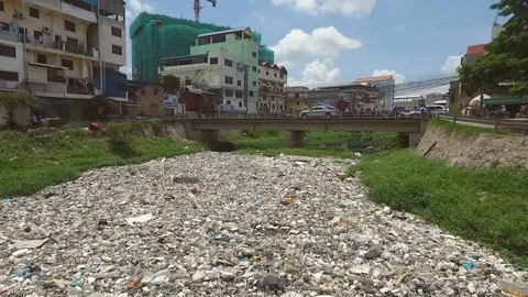 Close-up aerial view of polluted river crossing neighborhood, Cambodia. Video stock 101528906