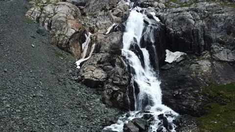 Close up aerial view of powerful mountain waterfall with melting snow patches Vídeos de archivo 335093678