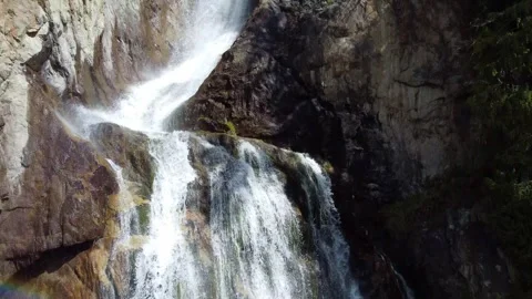 Close up aerial view of powerful waterfall cascading down rocky mountain cliff Vidéo 334625044