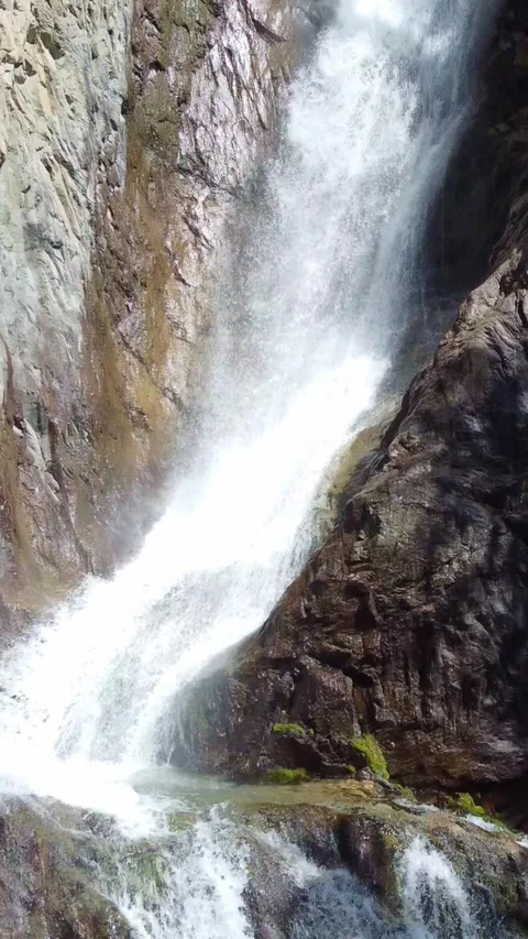 Close up aerial view of powerful waterfall cascading down rocky mountain cliff Stock Footage 336691350