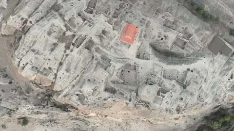 Close up aerial view of Uplistsikhe cave city structures from above with tour Vídeos de archivo 146510367