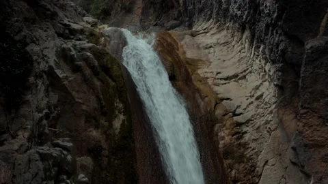 Close aerial view of a waterfall in between the mountains Stock Footage 172059445