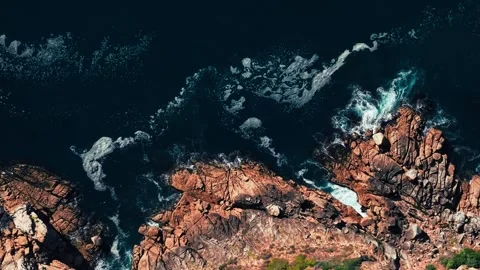 Close aerial of waves breaking on jagged rocky shoreline Stock Footage 340558884