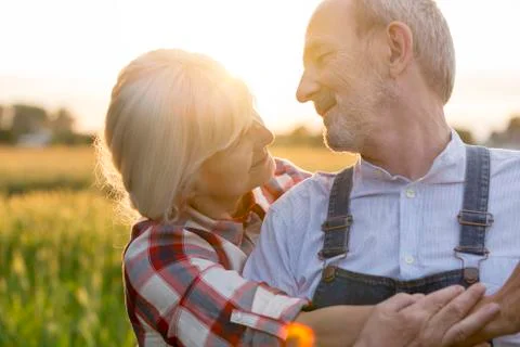 Close up affectionate senior couple hugging in rural field Stock Photos