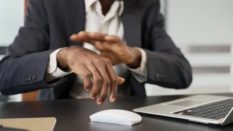 Close up. African american office worker holding wrist in pain while using Stock Footage 284555867