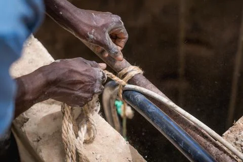 Close up of african hands at work in a construction site for a water well in Stock Photos
