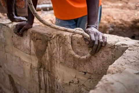 Close up of african hands at work in a construction site for a water well in 写真素材