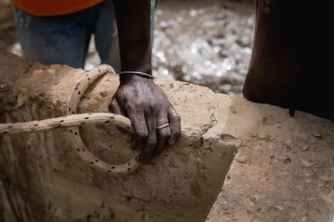 Close up of african hands at work in a construction site for a water well in Stock Photos