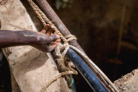 Close up of african hands at work in a construction site for a water well in Stock Photos
