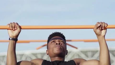 Close up of african man doing pull ups on horizontal workout outdoors Stock Footage 143501192