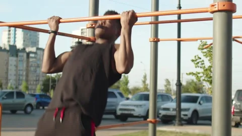 Close up of african man doing reverse grip pull-ups on horizontal workout Stock Footage 143506505