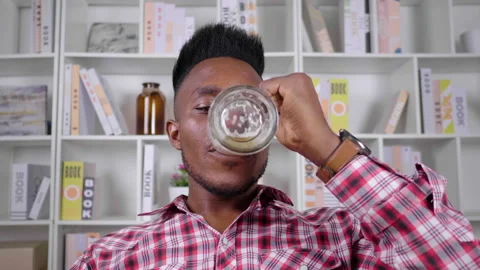 Close up of African man drinking beer while sitting on the sofa at home Vídeo Stock 164262695