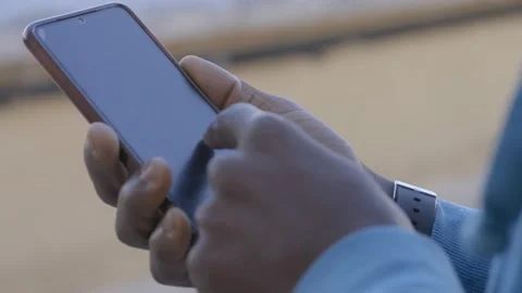 Close up of african man's hands typing on mobile phone Stock Footage 213313799