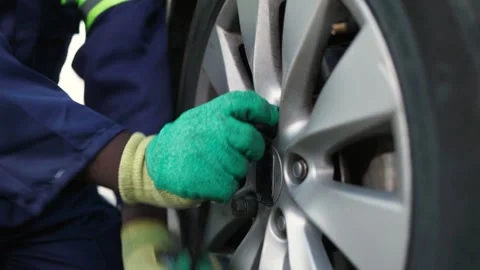 Close-up, African mechanic hands changing a car tire in his workshop Stock Footage 346643244