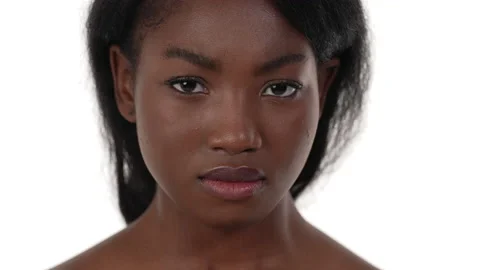 Close up of an african woman's face, looking at the camera, frowning, furrowing Stock Footage 156574383