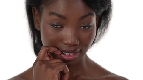 Close up of an african woman's face, looking down while biting her finger, Stock Footage 156587543