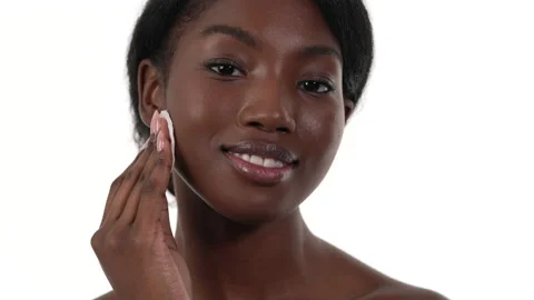 Close up of an african woman's face. Taking off her makeup or applying toner Stock Footage 156622741