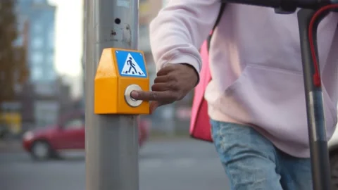 Close up of afro delivery guy on scooter pushing button of crossing light on Stock Footage 141446897