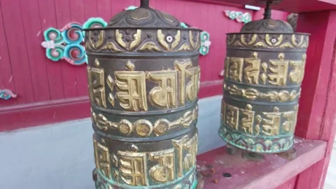 Close-up of aged Buddhist prayer wheels. Man's hand spinning prayer drums one by Stock Footage 223366144