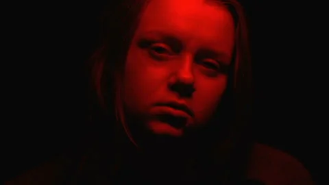Close-up aggressive female face in red light appearing from darkness, nightmares Vídeos de archivo 102314854
