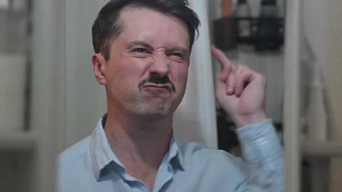 A close-up of an aggressive man displays various facial expressions, including Stock Footage 337111745