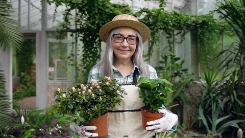 Close up of agreeable high-spirited carefree mature woman in hat which passing Stock Footage 132560804