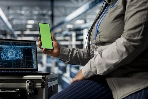 Close up of AI data center admin using green screen smartphone to check messages Stock Photos