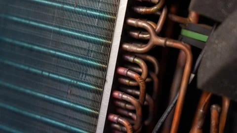 Close-up of air conditioner or refrigerator coils with copper pipes and met.. Видео 338319429
