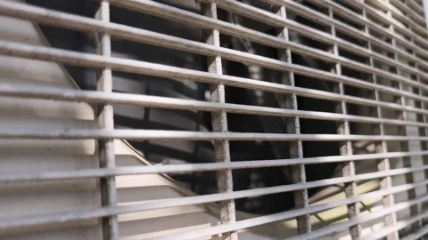 Close Up of Air Conditioner Outdoor Unit Fan Spinning Behind Metal Grille Stock Footage 339638701