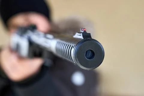 Close-up of air rifle muzzle and front fiber optic sight aiming at target. Fo Stock Photos