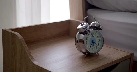 Close up alarm clock on table near bed in bedroom Stock Footage 127082183