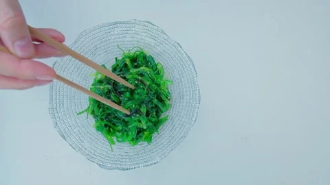 Close up of an algae with chopsticks. Soaked green wakame. Vídeos de archivo 201099409