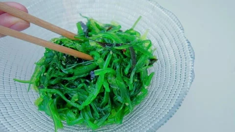 Close up of an algae with chopsticks. Soaked green wakame. Stock Footage 201099460