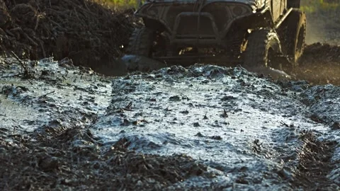 Close-up of an all-terrain vehicle driving through thick mud Stock Footage 344876341