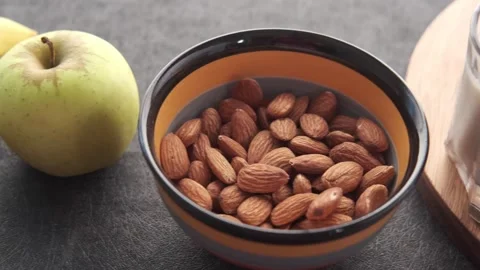Close up of almonds in bowl with apple and milk on table food healthy break.. Stock Footage 332407784