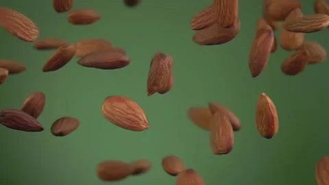 Close-up of almonds flying and rotating on the olive green background Stock Footage 168241038