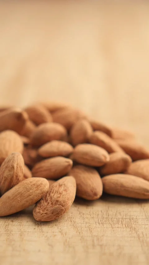 Close up of almonds on a wooden table slow motion. 스톡 동영상 332032224