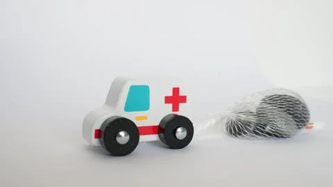 Close up of an ambulance toy pulling a heavy load (stones). Conceptual for .. Stock Photos