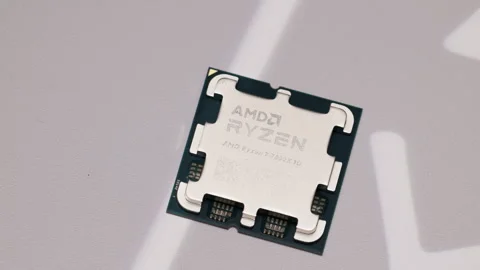 Close-up of AMD Ryzen 7 7800X3D CPU on textured surface. Ideal for tech Stock Footage 300994967