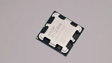 Close-up of AMD Ryzen 7 7800X3D CPU on textured surface. Stock Footage 301168449